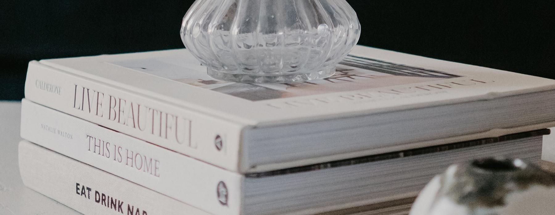 a stack of books and vases on a table